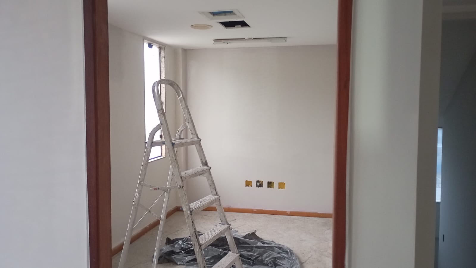 Ambiente em fase de pintura com escada